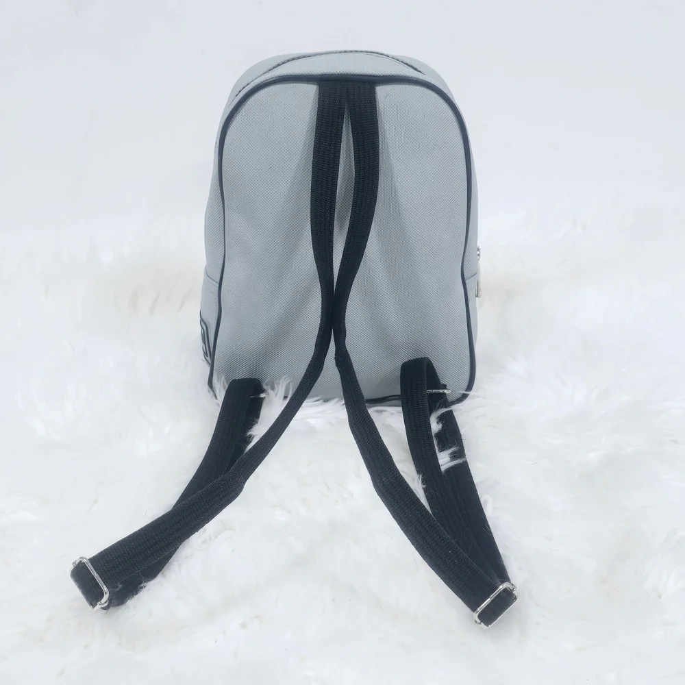 Lacoste mini backpack in a soft light blue shade with navy blue trim accents.